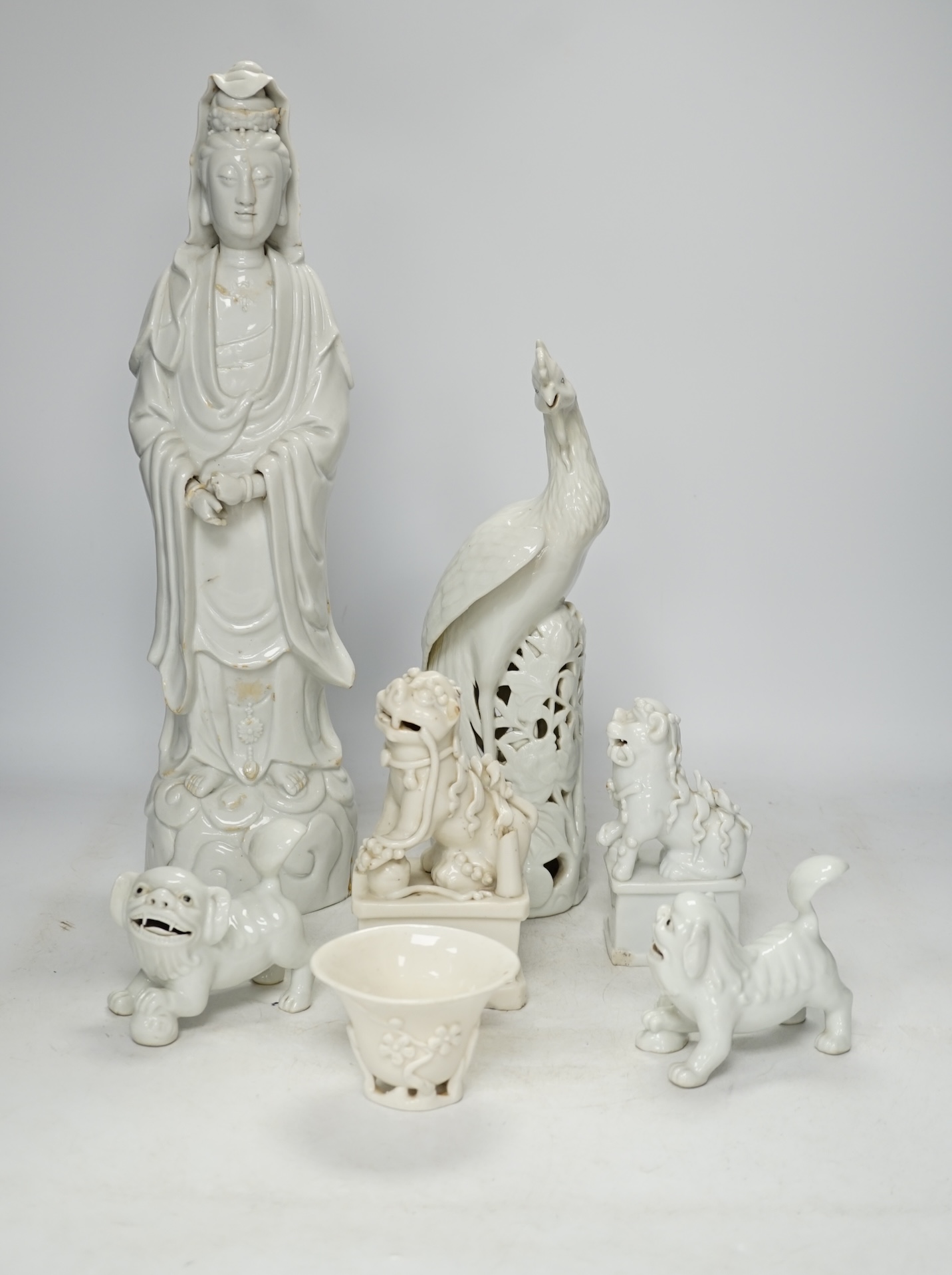 Seven Chinese blanc de chine pieces to include a pair of lion dogs and a phoenix, 17th century and later, largest 44cm high. Condition - varies, poor to fair